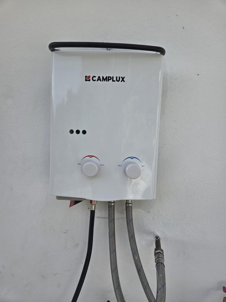 Chauffe-eau Camplux blanc fixé sur un mur