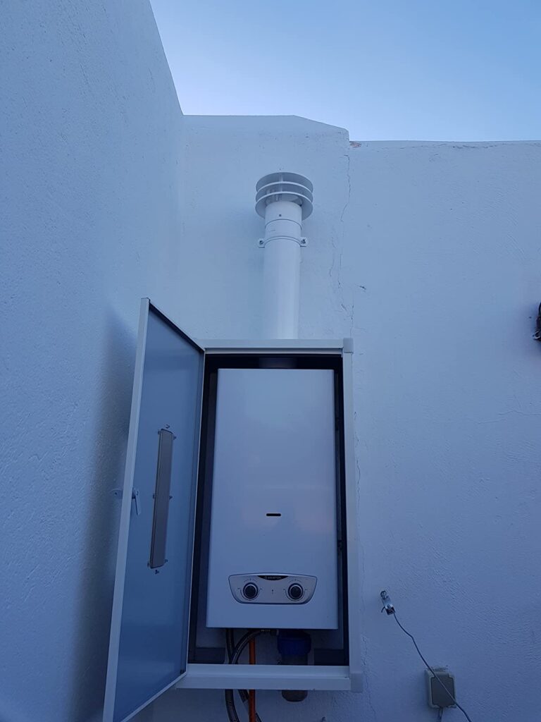 Chauffe-eau à gaz Ariston Fast RX dans son coffret extérieur ouvert