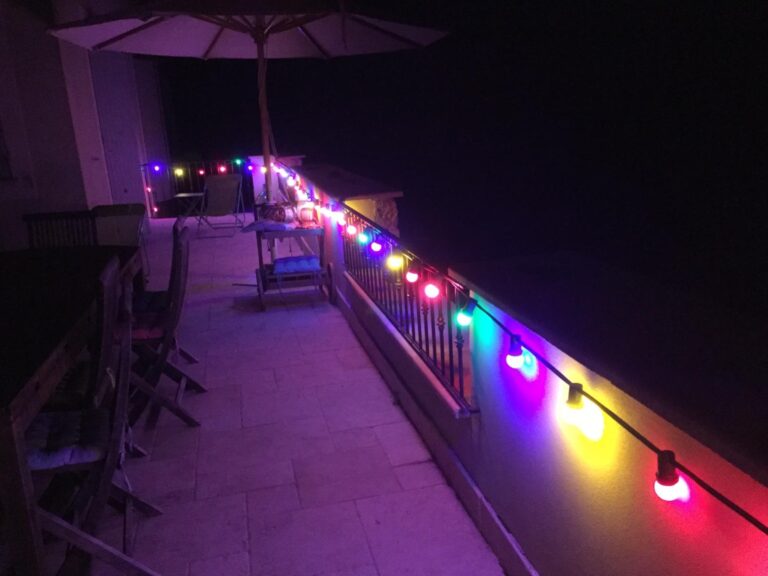 Guirlande lumineuse multicolore allumée sur un balcon
