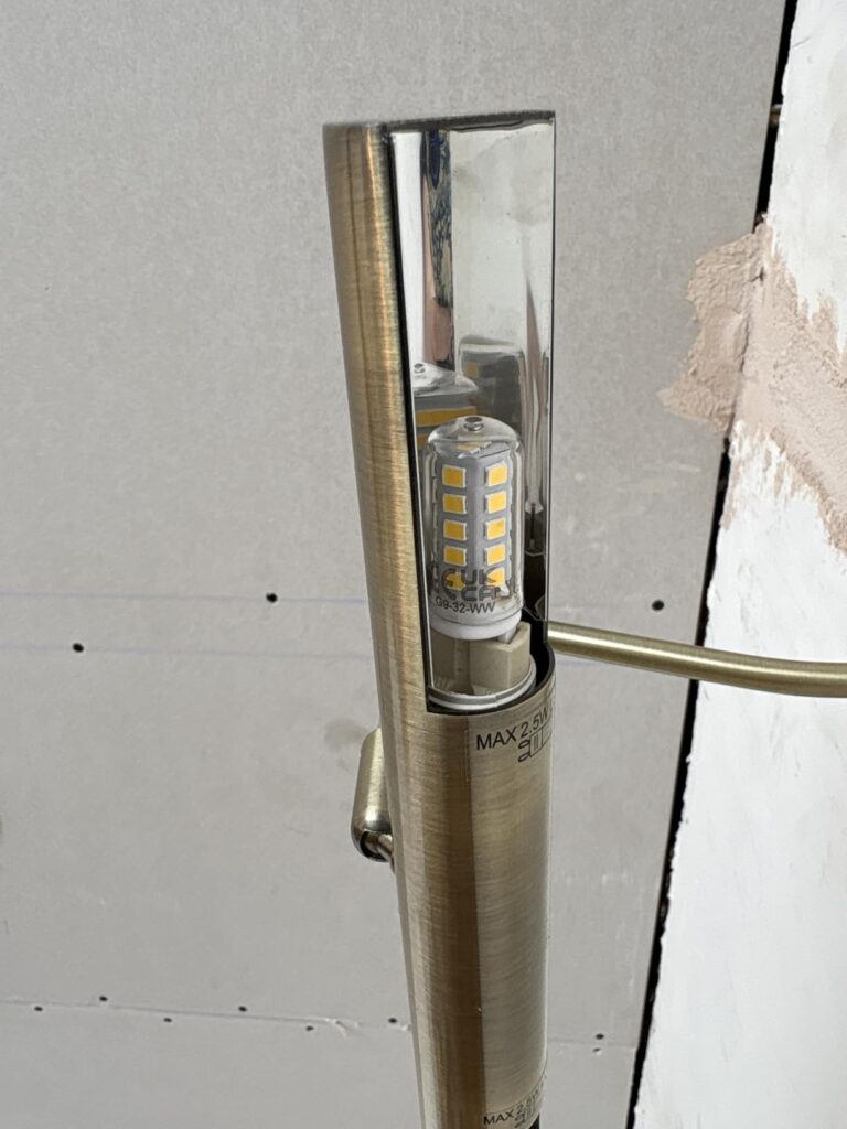 Ampoule LED G9 insérée dans un luminaire en métal.