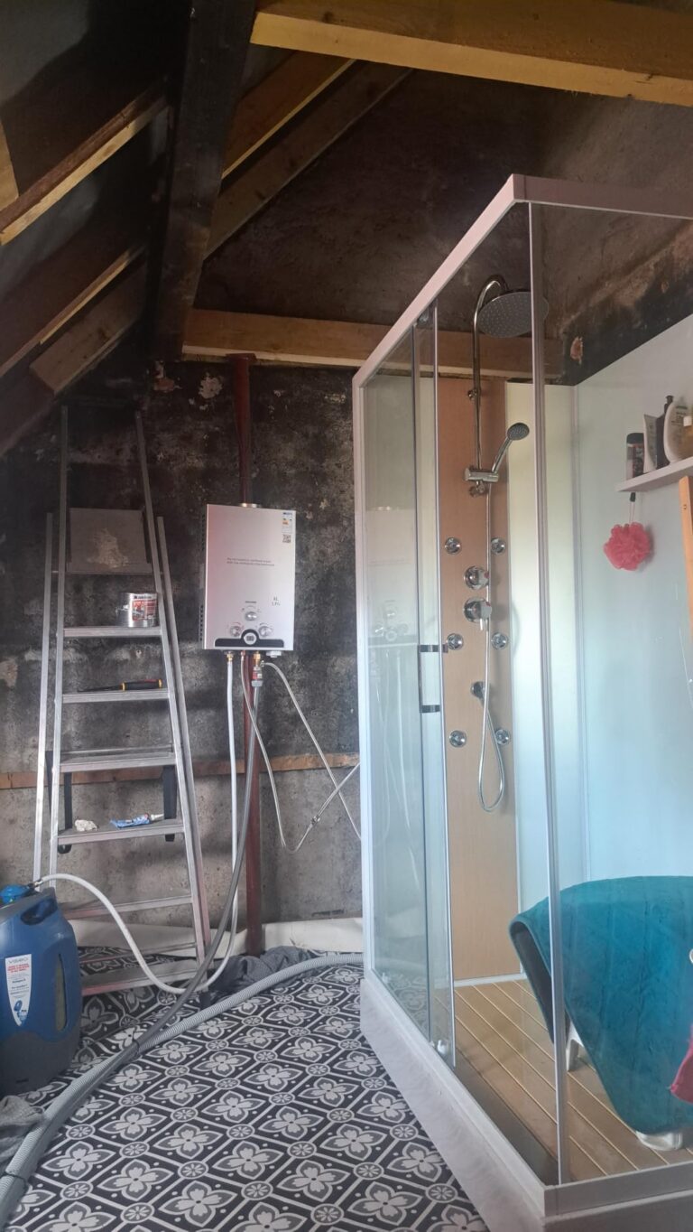 Chauffe-eau au gaz installé près d'une cabine de douche