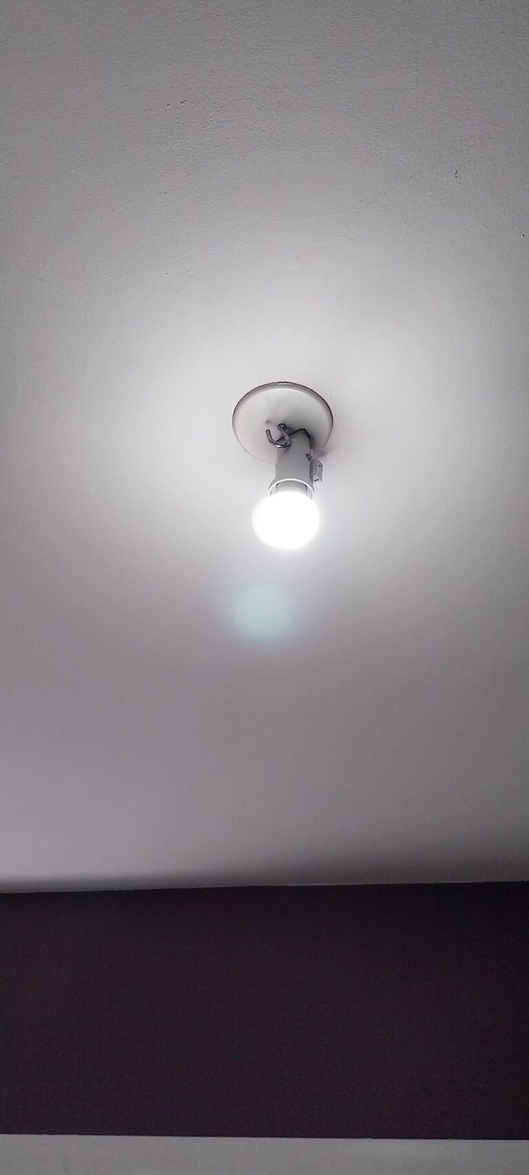 Ampoule LED vissée et allumée au plafond