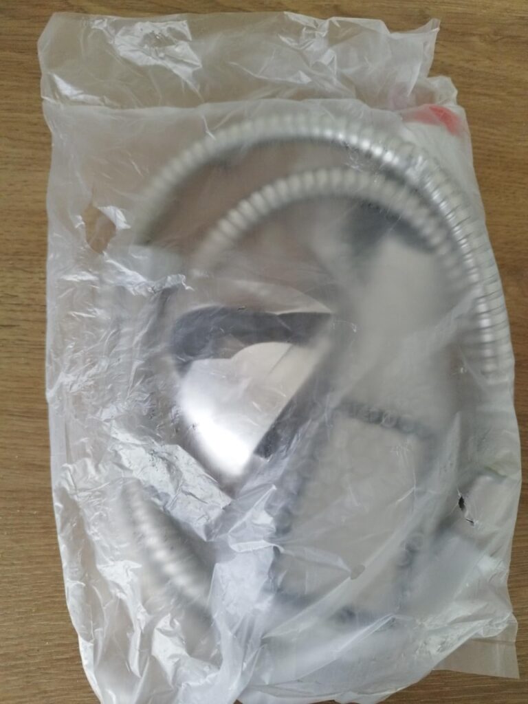 Flexible de douche et douchette dans un sachet plastique
