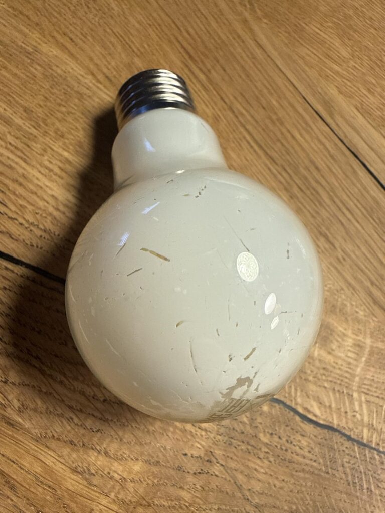 Ampoule LED Philips posée sur un parquet.