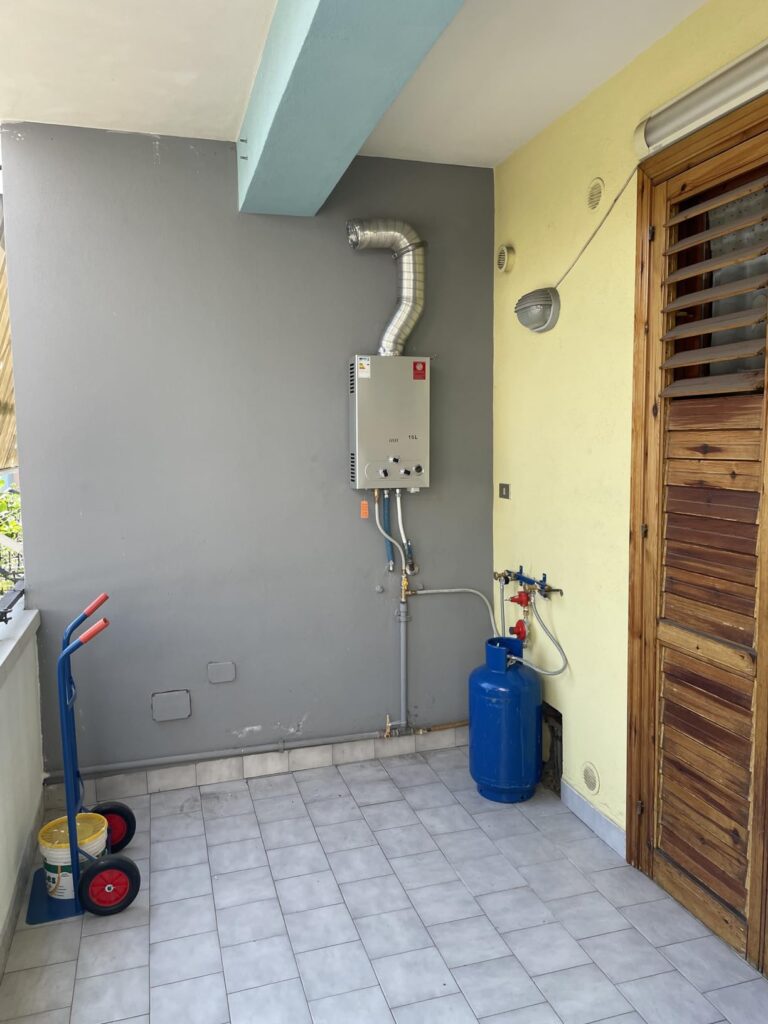 Chauffe-eau à gaz raccordé à une bouteille de gaz sur une terrasse