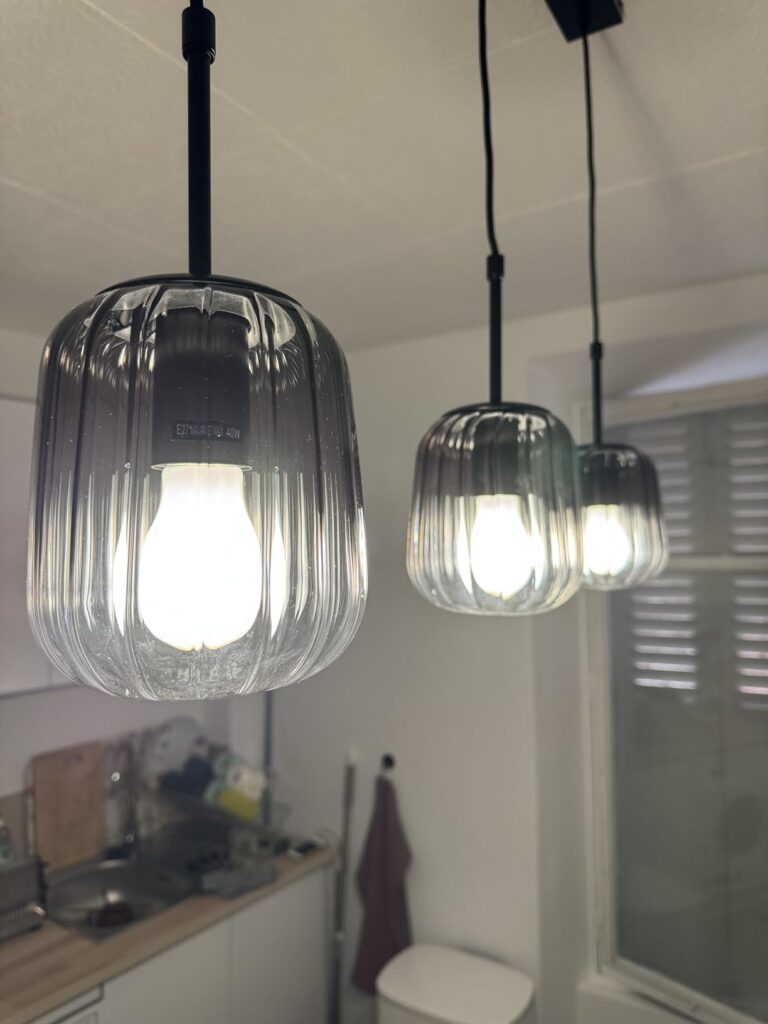 Gros plan sur l'ampoule LED allumée dans une suspension en verre