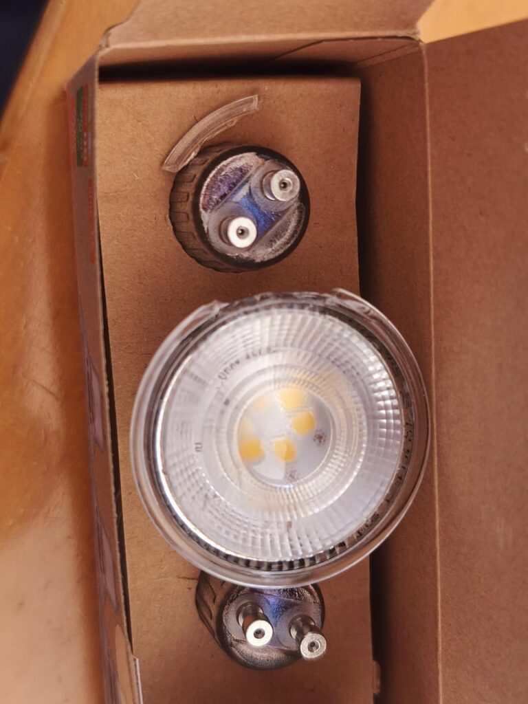 Ampoule LED avec collerette brisée dans son emballage.