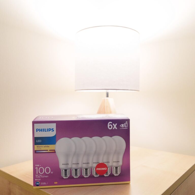 Boîte d'ampoules posée devant une lampe allumée