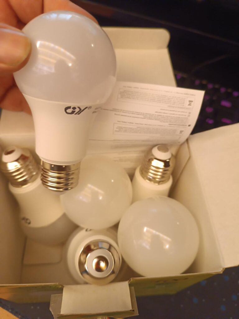 Ampoule LED GY tenue en main au-dessus de sa boîte