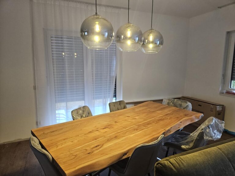 Trois ampoules LED installées dans des suspensions en verre au-dessus d'une table à manger