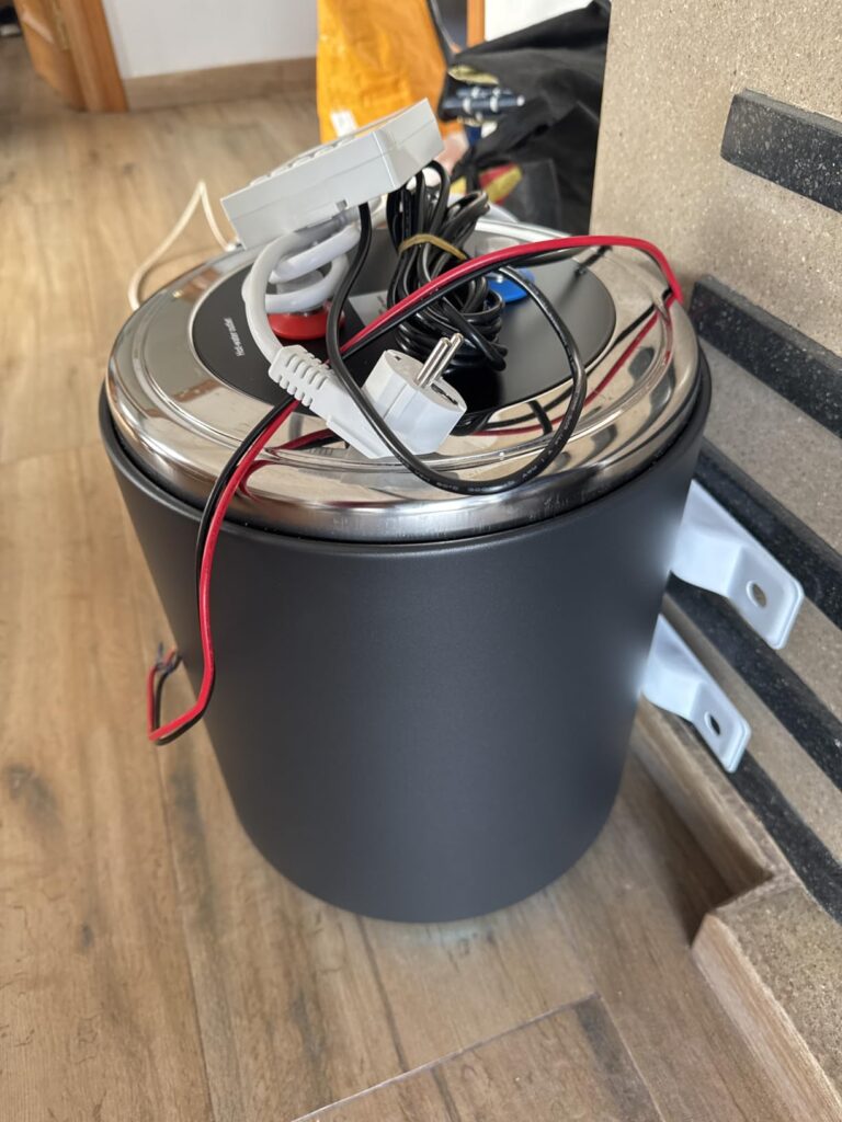 Chauffe-eau compact noir pour camping-car avec ses câbles et fixations