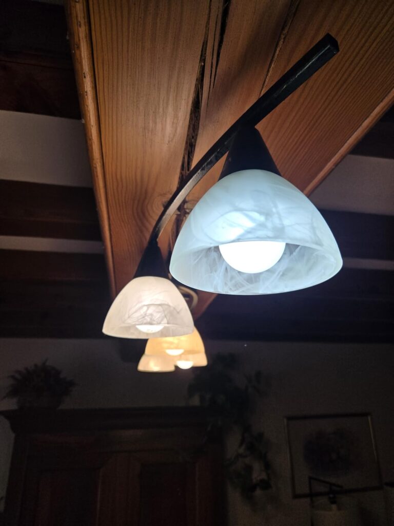 Gros plan sur un abat-jour en verre laissant voir l'ampoule LED allumée
